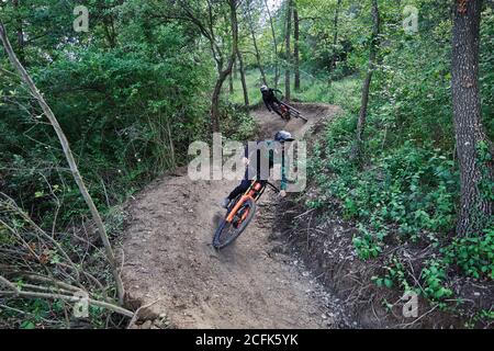 Cycliste masculin en vélo pour faire de la descente le long d'un sentier sablonneux et réaliser des tours extrêmes dans les bois Banque D'Images