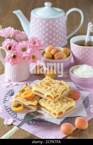 décoration de table avec gâteau à l'abricot avec crumble, plats à thé et bouquet de roses Banque D'Images
