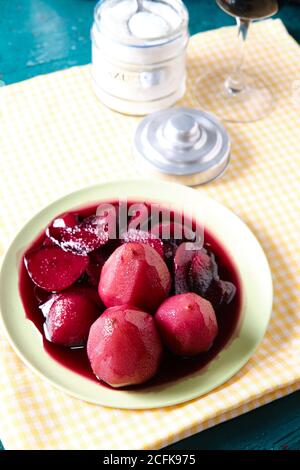 De dessus de savoureux vin rouge poires pochées dans l'assiette placé sur une table dans le restaurant Banque D'Images