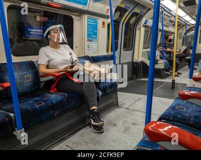 Les passagers qui utilisent le métro de Londres suivent les règles de sécurité Covid-19 du gouvernement en matière de port d'une couverture et de distances sociales. Banque D'Images