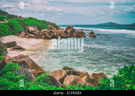 Magnifique plage paradisiaque pittoresque avec des rochers en granit, du sable blanc et des palmiers sur un paysage tropical, Seychelles. Banque D'Images