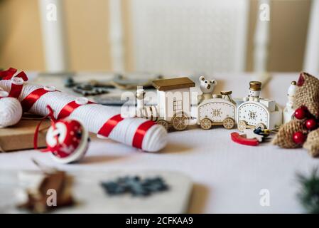 Figurines blanches de train et d'animaux placées avec le présent enveloppé Sur une table en papier artisanal pour les fêtes de Noël Banque D'Images