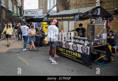 Stands de nourriture sur le marché de Brick Lane offrant aux visiteurs et aux touristes une variété d'aliments ethniques. Banque D'Images