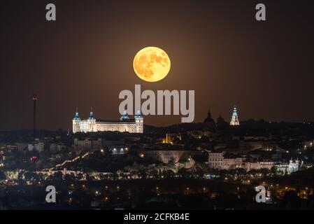 Vue incroyable sur la pleine lune dans le ciel sombre sur la vieille ville avec un palais historique lumineux Banque D'Images