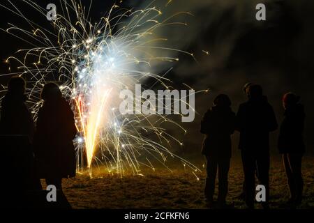 La fontaine de feu d'artifice du nouvel an et les gens comme silhouettes sont debout dans l'obscurité pour célébrer la nouvelle année à minuit, espace de copie Banque D'Images