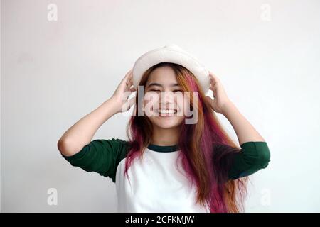 jolie femme asiatique souriant joyeusement avec des cheveux colorés dans habillé décontracté comme style de vie hipster, concept de mode de cheveux. Banque D'Images