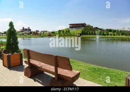 Village allemand, Krasnodar, Russie - 09 juin 2019 : bancs près d'un étang avec une fontaine dans un quartier urbain confortable. L'inscription en russe Banque D'Images