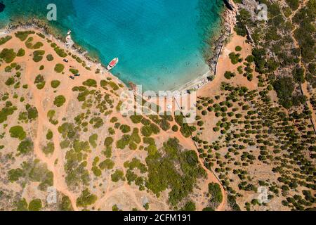 Vue aérienne par drone d'une petite plage sur une côte rocheuse et aride et un océan limpide (Kolokitha, Crète, Grèce) Banque D'Images