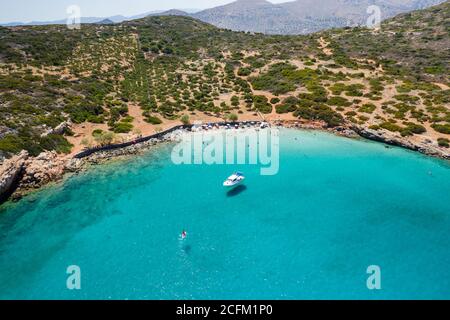 Vue aérienne par drone d'une petite plage sur une côte rocheuse et aride et un océan limpide (Kolokitha, Crète, Grèce) Banque D'Images