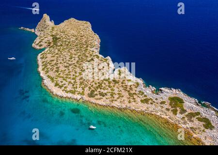 Vue aérienne des bateaux dans un océan bleu clair cristal à côté d'une petite île (Kolokitha, Crète, Grèce) Banque D'Images