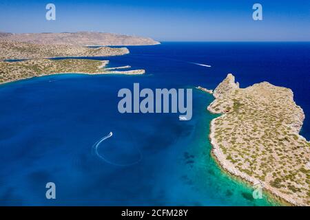 Vue aérienne des bateaux dans un océan bleu clair cristal à côté d'une petite île (Kolokitha, Crète, Grèce) Banque D'Images