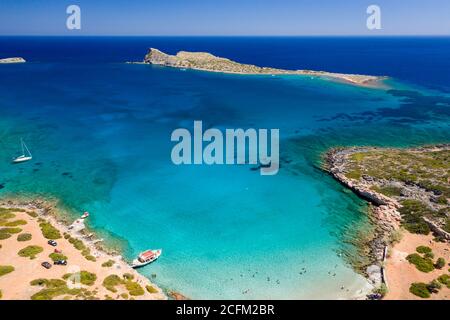 Vue aérienne par drone d'une petite plage sur une côte rocheuse et aride et un océan limpide (Kolokitha, Crète, Grèce) Banque D'Images