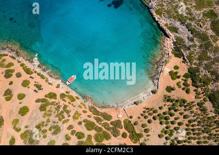 Vue aérienne par drone d'une petite plage sur une côte rocheuse et aride et un océan limpide (Kolokitha, Crète, Grèce) Banque D'Images