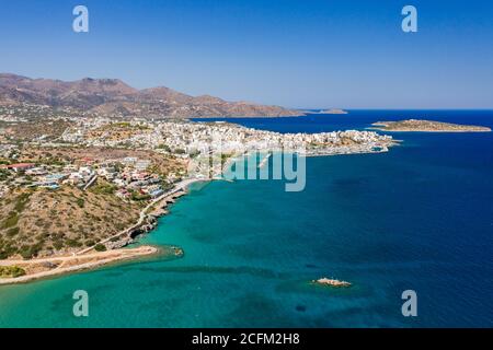 Vue aérienne de la ville pittoresque d'Aghios Nikolaos in Crète (Grèce) entourée d'un océan aux eaux cristallines Banque D'Images