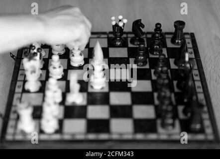 Main du joueur d'échecs dans la décision couleur noir et blanc. Banque D'Images