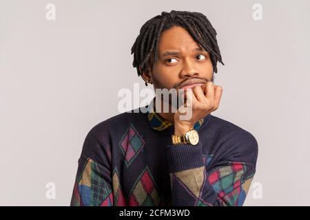 Triste homme africain pensif avec des dreadlocks pendus la tête sur la main et pensant, contemplant l'avenir, attendant et rêver. Prise de vue en studio en intérieur Isola Banque D'Images