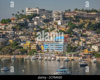 Acapulco, Mexique - 25 novembre 2008 : promenade de Playa tlacopanocha avec une colline à l'arrière chargée de bâtiments en hauteur sous un ciel bleu clair. Quai avec Banque D'Images