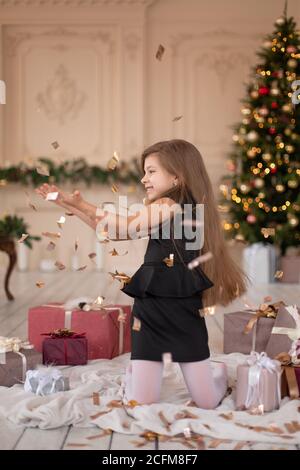 Petites filles jetés confetti. Magie de Noël. Des moments joyeux d'une enfance heureuse. Banque D'Images