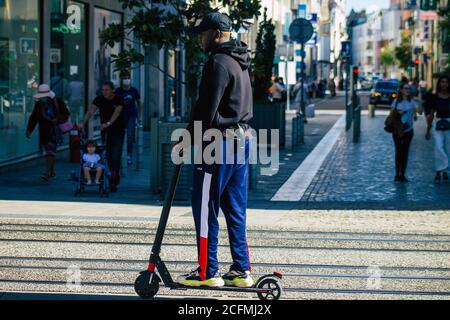 Reims France 04 septembre 2020 vue de personnes non identifiées roulant avec un scooter électrique dans les rues de Reims, fonctionnant avec un petit utilitaire i Banque D'Images