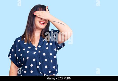 Jeune femme de taille plus portant des vêtements décontractés souriant et riant avec la main sur le visage couvrant les yeux pour la surprise. Concept aveugle. Banque D'Images