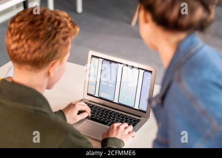 Deux jeunes collègues regardent des croquis électroniques de nouveaux mobiles applications Banque D'Images
