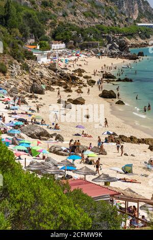 Belle vue sur la plage avec des touristes et des parasols lors d'une journée ensoleillée près de Setubal, Lisbonne, Portugal Banque D'Images