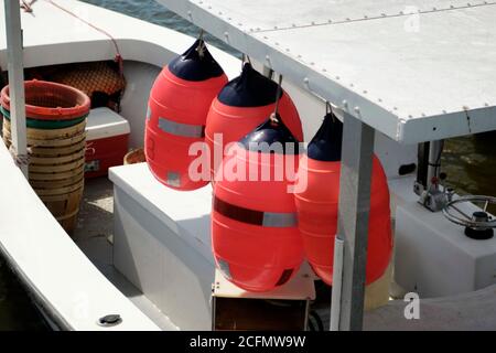 Flotteurs aux couleurs vives suspendus sur un petit bateau de pêche. Banque D'Images