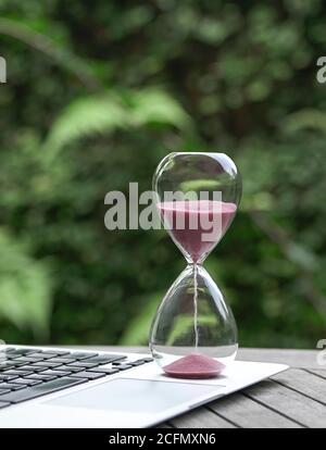 HourGlass sur ordinateur portable. Concept de gestion du temps, de compte à rebours et de délais. Banque D'Images