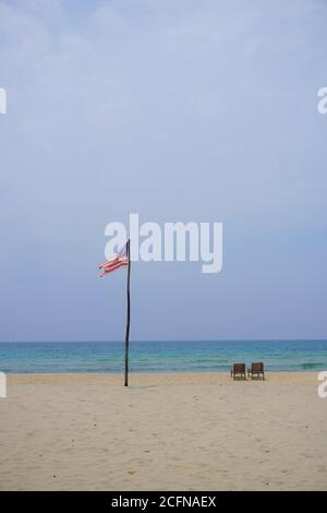 Drapeau malaisien ordonnant sur la plage de l'île de Tioman pendant la chaude journée de l'après-midi. Banque D'Images
