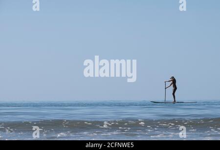 Nord Queensland Australie. Montez en paddle-boarding sur four Mile Beach à Port Douglas North Queensland. Banque D'Images