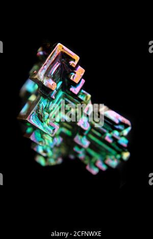 Bismuth (bismuthum - Bi) cristal métallique de couleur isolé sur fond noir Banque D'Images