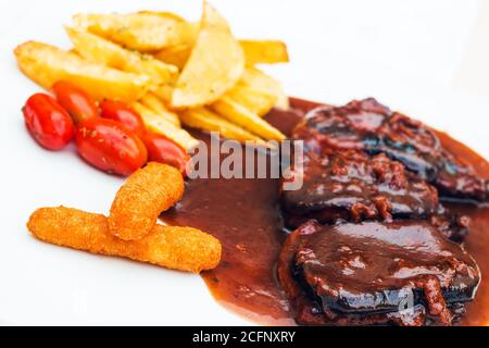 Côtes de porc et doigts de poulet avec sauce barbecue et un côté frites et tomates cerises (sélection) Banque D'Images