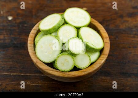 Émincé de courgettes dans un bol sur fond de bois. Légumes, ingrédients et aliments de base. Une alimentation saine. Banque D'Images