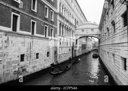 Gondoles flottant sur le canal en direction du pont des Soupirs (Ponte dei Sospiri). Venise, Italie. Perspective. Photo vieillie. Noir et blanc. Banque D'Images