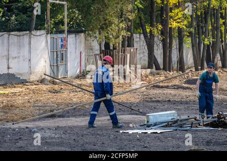 Moscou. Russie. 06 septembre 2020 les travailleurs de la construction qui travaillent dans les uniformes et les casques de sécurité sur le chantier transfèrent manuellement la construction Banque D'Images