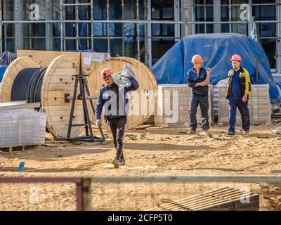 Moscou. Russie. 06 septembre 2020 les travailleurs de la construction qui travaillent dans les uniformes et les casques de sécurité sur le chantier transfèrent manuellement la construction Banque D'Images