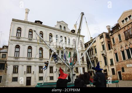 VENISE, ITALIE - 15 FÉVRIER 2015 : les enfants s'amusent à sauter sur le trampoline élastique fixé avec des bandes en caoutchouc pendant le carnaval. Banque D'Images