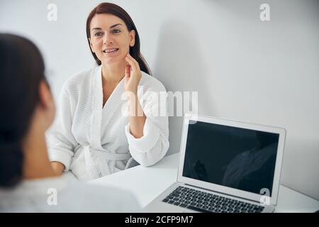Femme souriante écoutant attentivement un médecin Banque D'Images