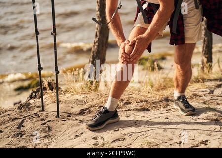 Homme blessant la jambe en allant marche nordique dans la nature Banque D'Images