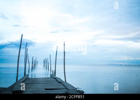 Photographie en longue exposition d'un pont en bois dans la mer bleue Banque D'Images