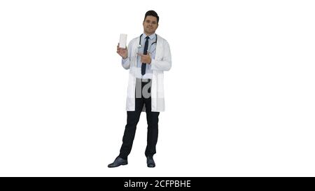 Médecin mature en blanchitavoine décrivant de nouvelles pilules en boîte sur fond blanc. Banque D'Images