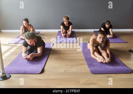 Un groupe d'entraînement attrayant se repose après avoir fait du yoga ensemble Banque D'Images