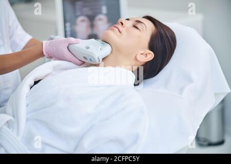 Femme se détendant pendant une procédure cosmétique dans un salon de beauté Banque D'Images