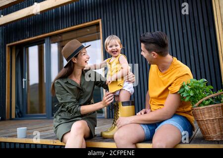 Jeune famille avec petite fille à l'extérieur, week-end loin dans la maison de conteneurs en campagne. Banque D'Images