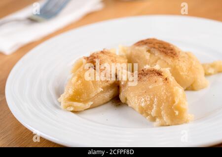 Halva de farine turque ou un Helvasi sur une assiette blanche avec cannelle sur le dessus. Banque D'Images