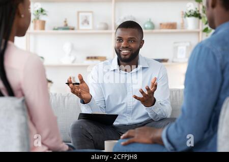 Psychothérapie familiale. Sympathique Black Therapist consultant un couple afro-américain à son bureau Banque D'Images