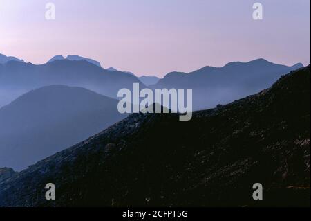 Le coucher du soleil approche le paysage accidenté au-delà de Lago Rosamarina en Sicile, en Italie, avec une brume rose douce. Banque D'Images