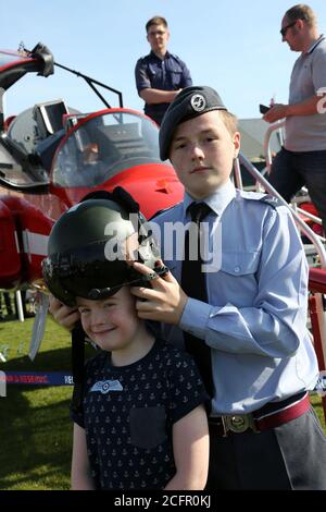 Ayr, Ayrshire, Écosse 05 sept 2015, spectacle aérien international écossais. Jeune femme le cadet de l'air met l'helemt volant sur le jeune garçon à un affichage statique avec la flèche rouge Banque D'Images