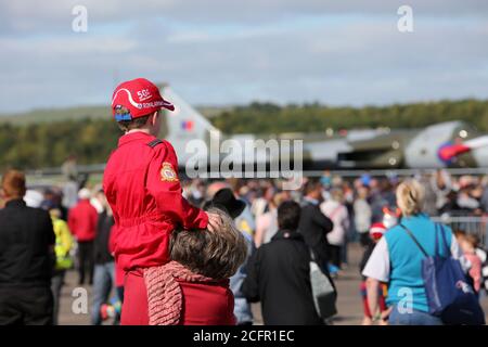 Ayr, Ayrshire, Écosse 05 sept 2015, Scottish International Airshow> Jeune garçon aux flèches rouges en costume volant sur ses épaules de père regardant l'Avro Vulcan taxer Banque D'Images