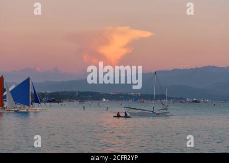 Boracay, Philippines - 27 janvier 2020 : coucher de soleil sur l'île de Boracay. Voile et autres bateaux traditionnels avec des touristes sur la mer sur le fond de Banque D'Images